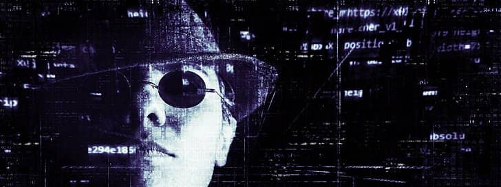 Silhouette of a hacker over lines of code